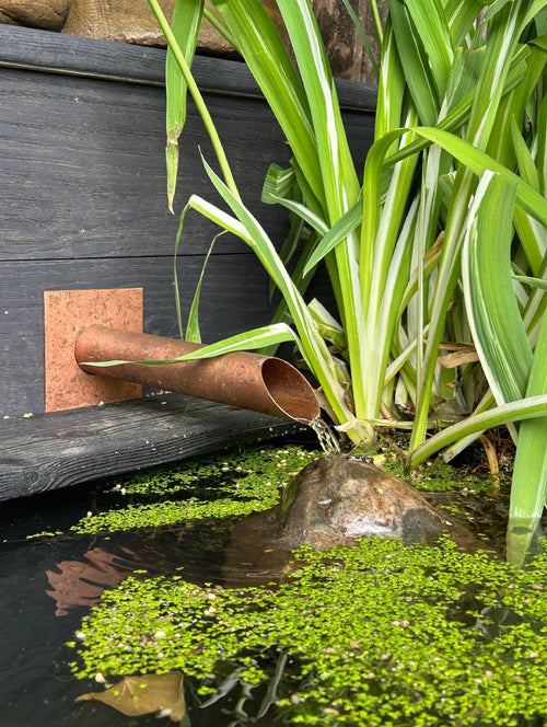Handmade 42mm copper water spout installed on a wall