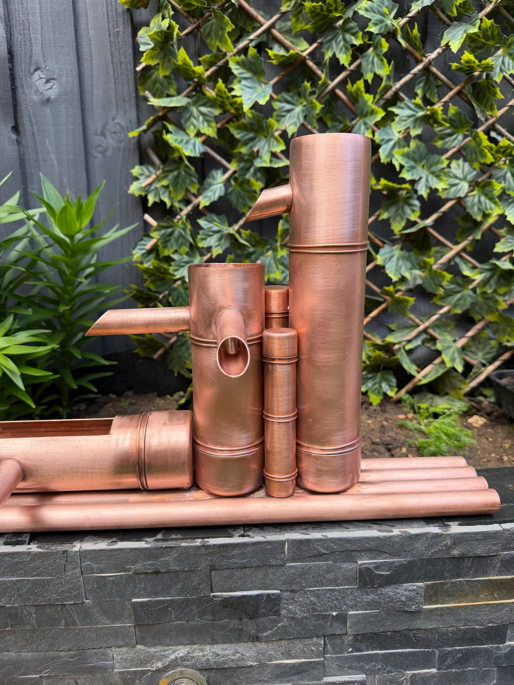 Bamboo-inspired copper garden fountain by Spoutcraft Studio