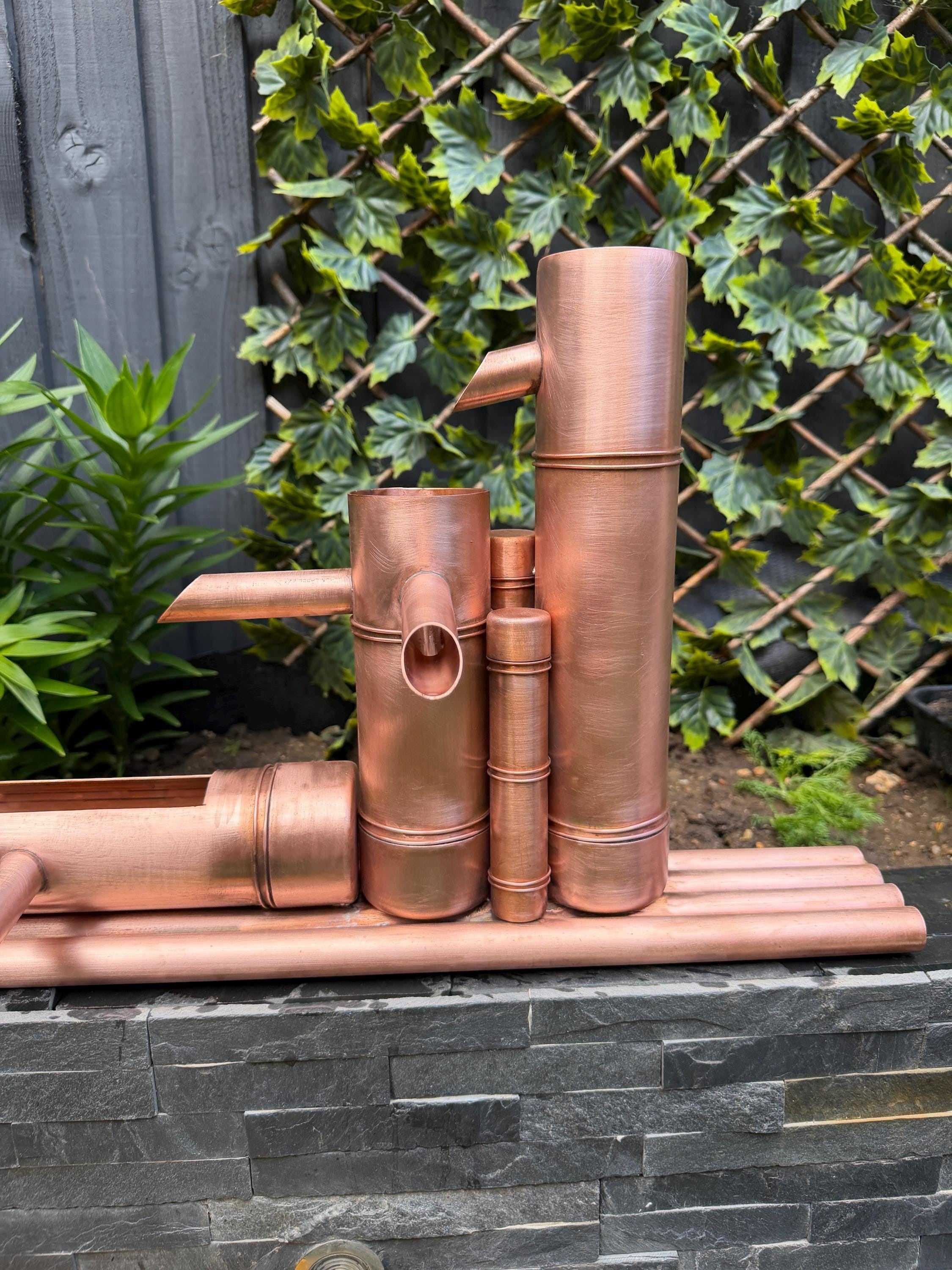Bamboo-inspired copper garden fountain by Spoutcraft Studio