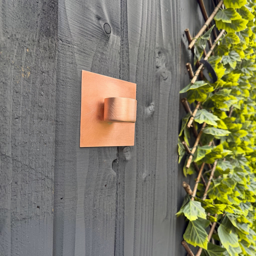 Wall-mounted copper candle holder for outdoor entertaining spaces