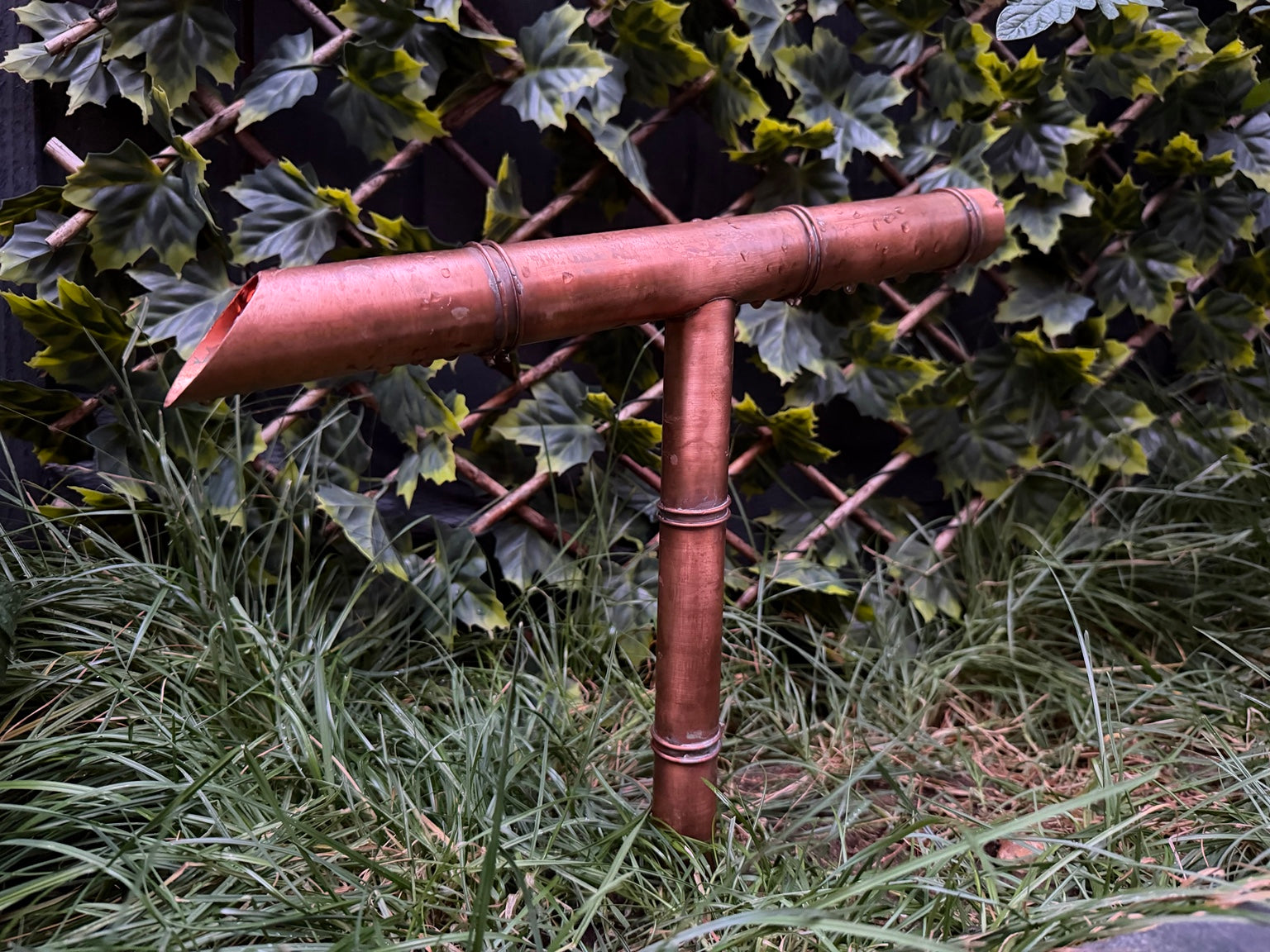 Japanese inspired copper tee water spout in garden setting